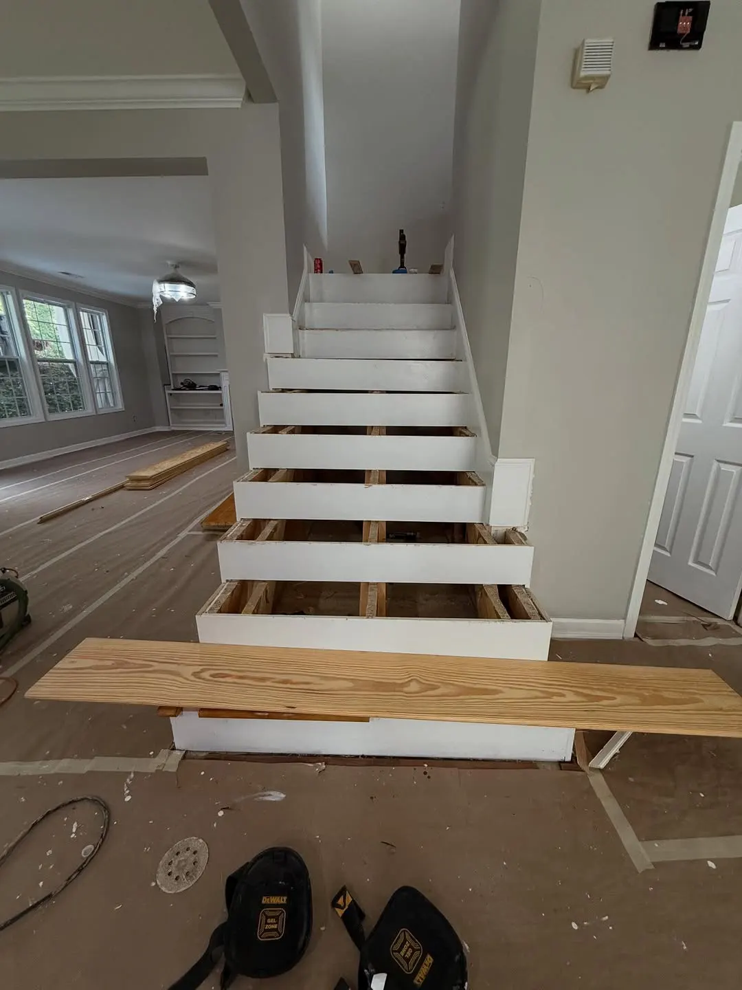 Stairs with old treads removed and a new board ready